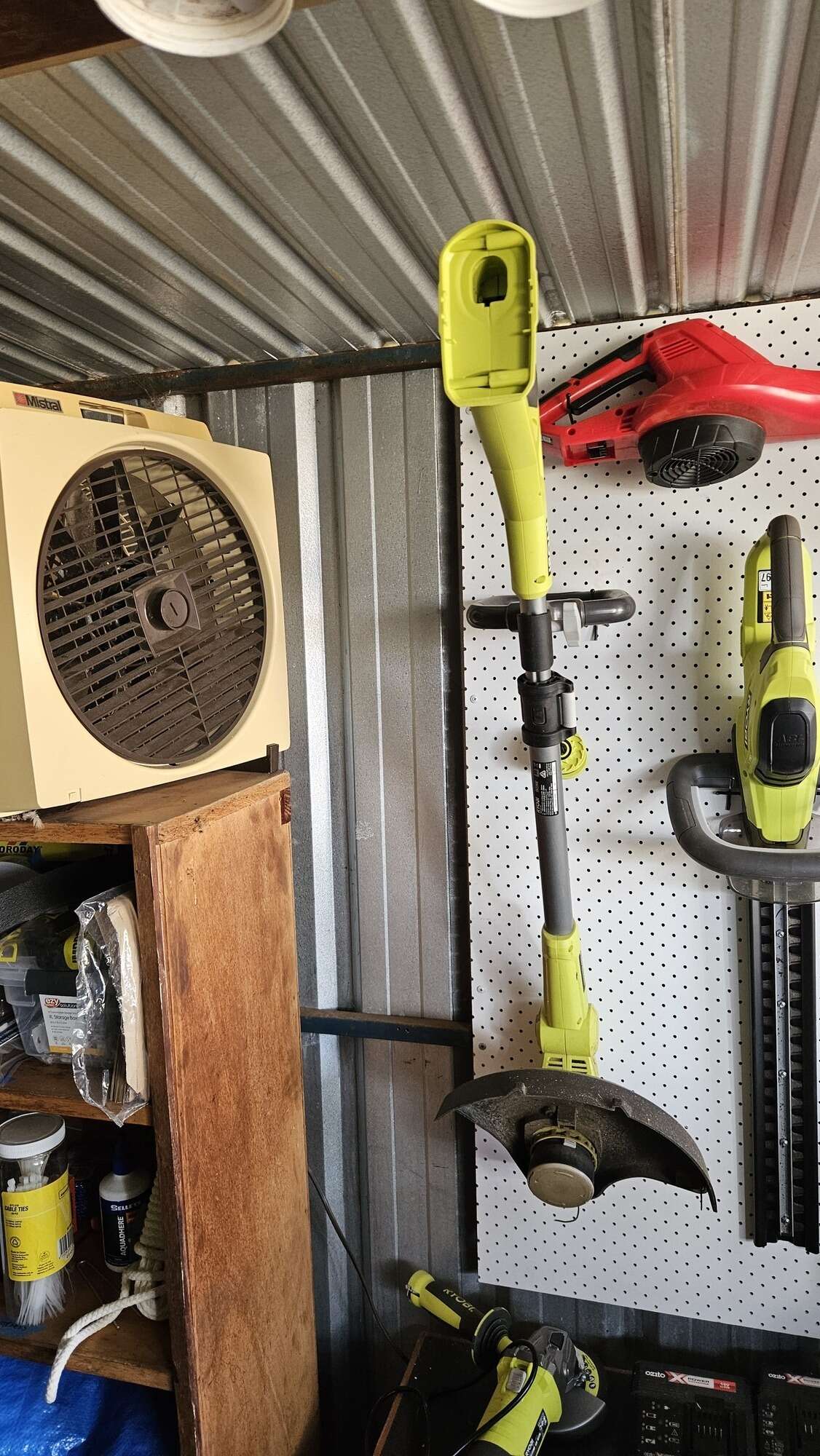 The wall of my shed, showing a nice gap between a shelf and pegboards.