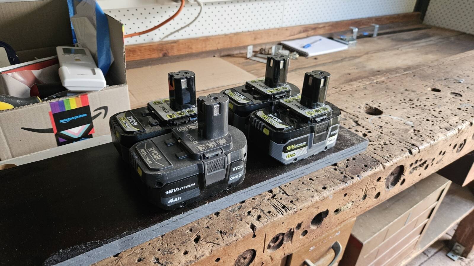 4 Ryobi batteries arranged on a piece of rectangular wood in a 2x2 grid. The batteries fit nicely on the short side, and more can fit on the long side.