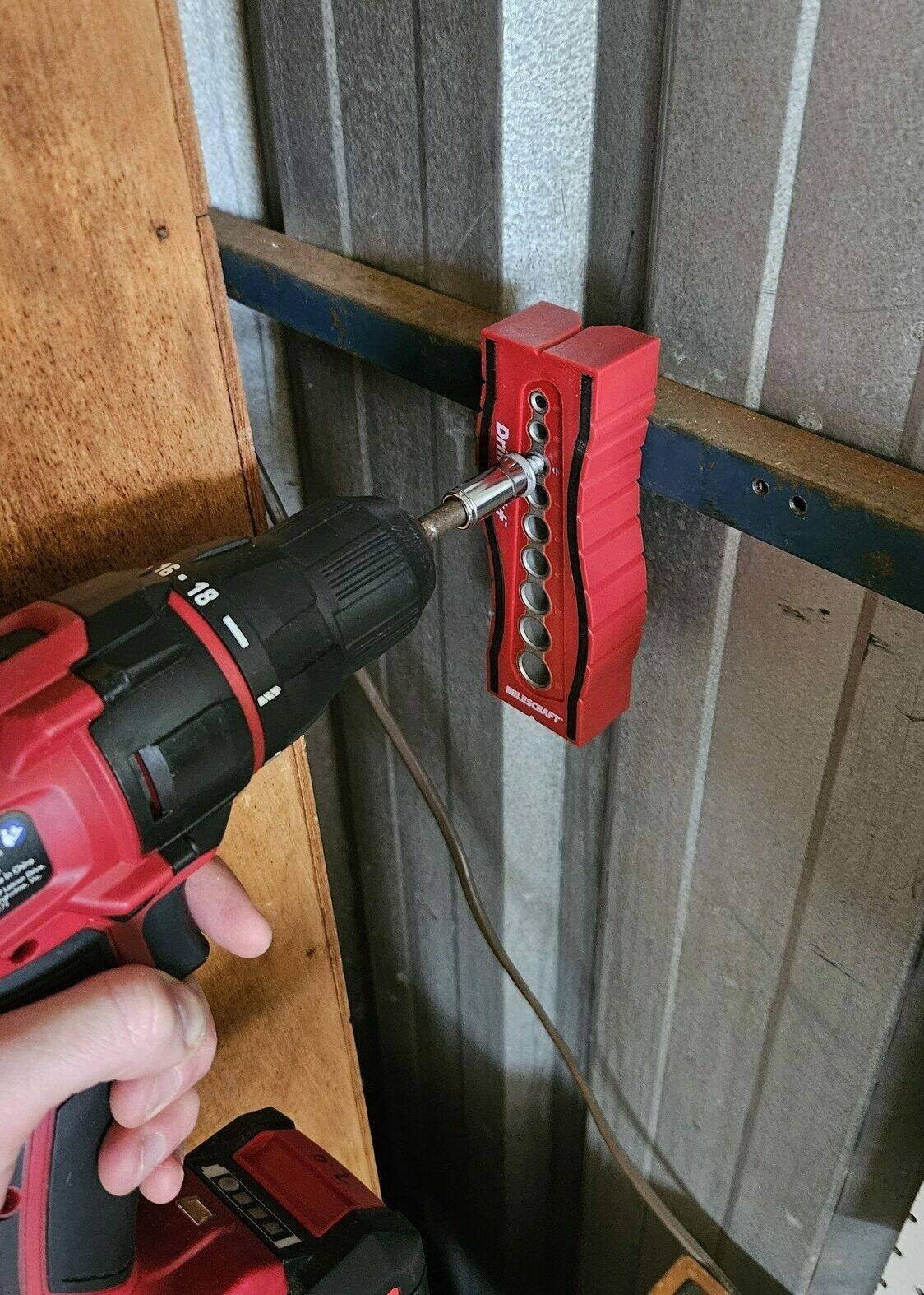 A cordless drill being used to screw in a self-drilling screw, supported with a 'drill block' tool to keep it straight.