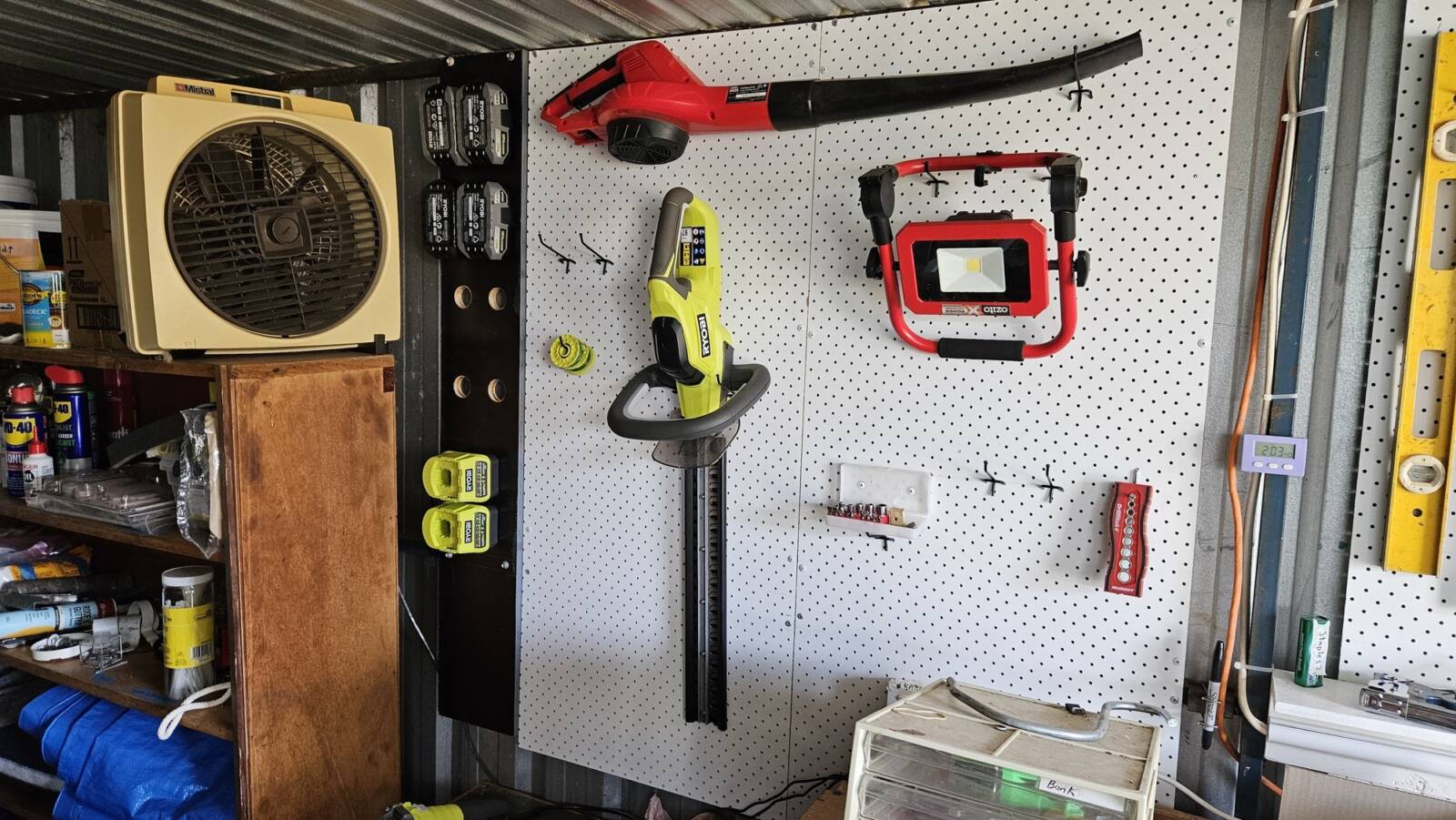 A view of the battery storage and its surroundings, including a shelf and pegboards.